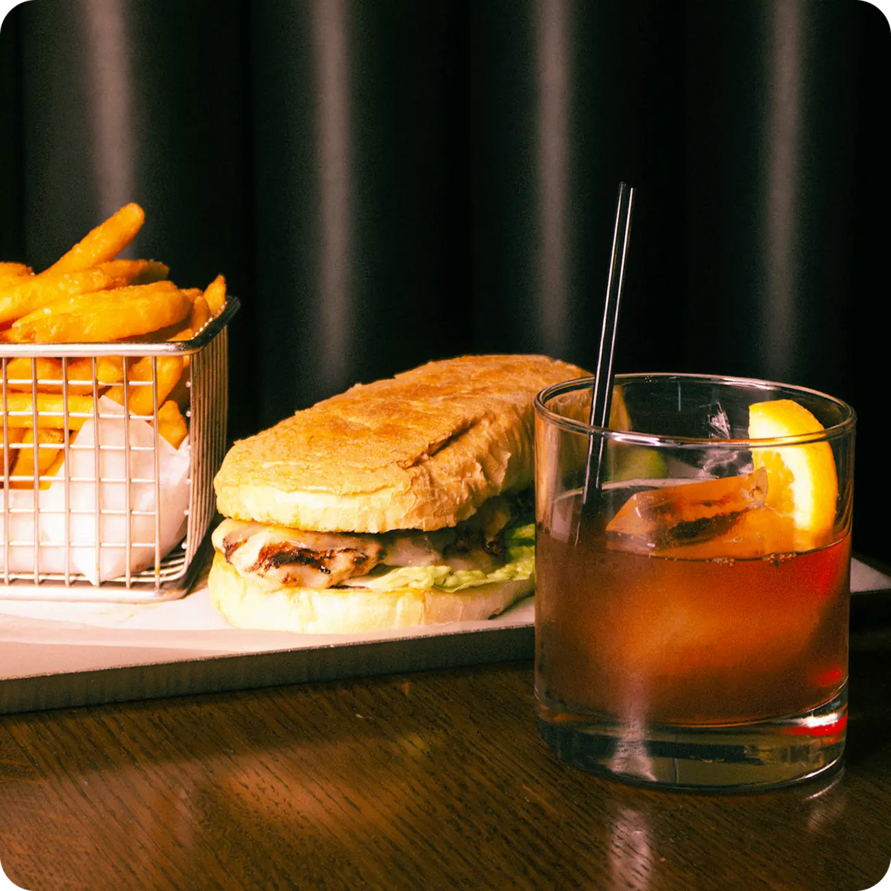 Sandwich, fries, and cocktail at The Office Dining and Spirits